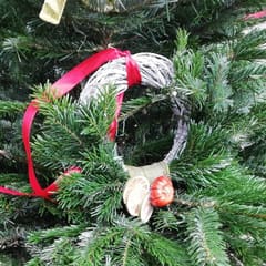 A handmade Christmas wreath with a red ribbon, dried orange slices and fresh greenery, made at Pitchcombe Fresh